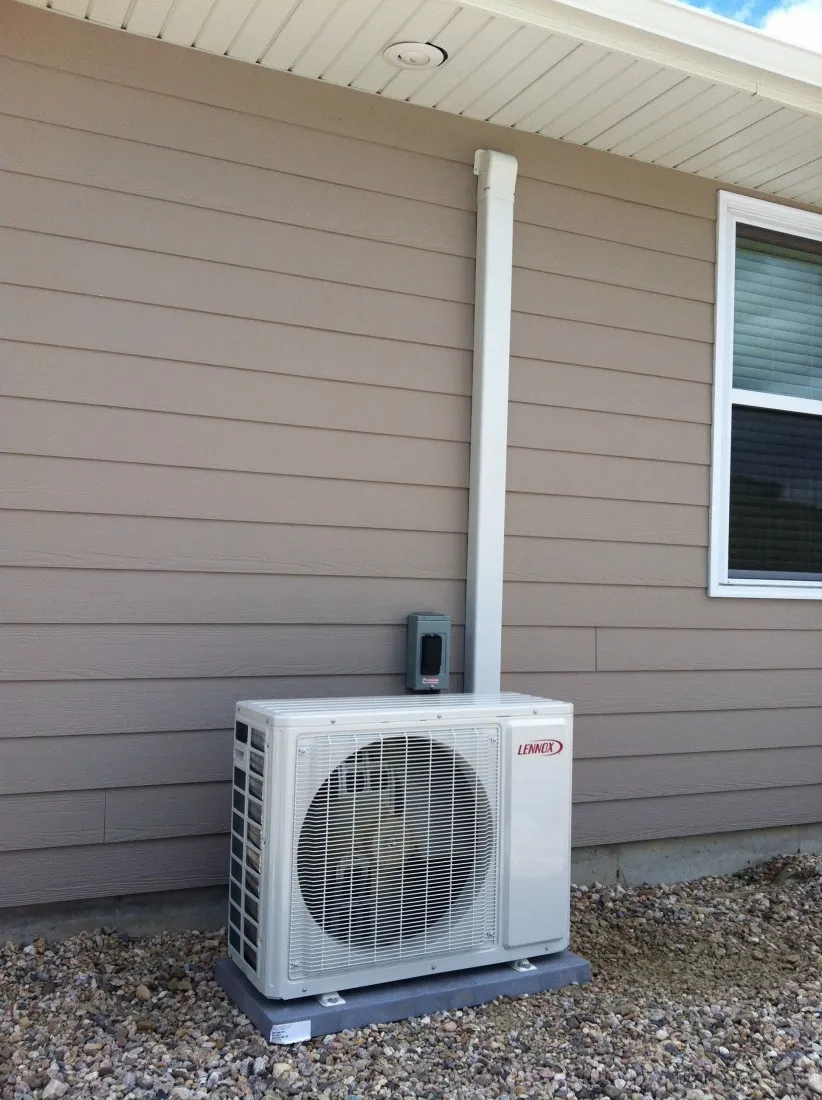 Lennox outdoor unit installed by Lucas Heating and Air on a composite pad beside a Utah home