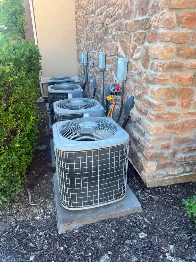 Row of outdoor AC condensers at a West Jordan apartment complex during seasonal maintenance